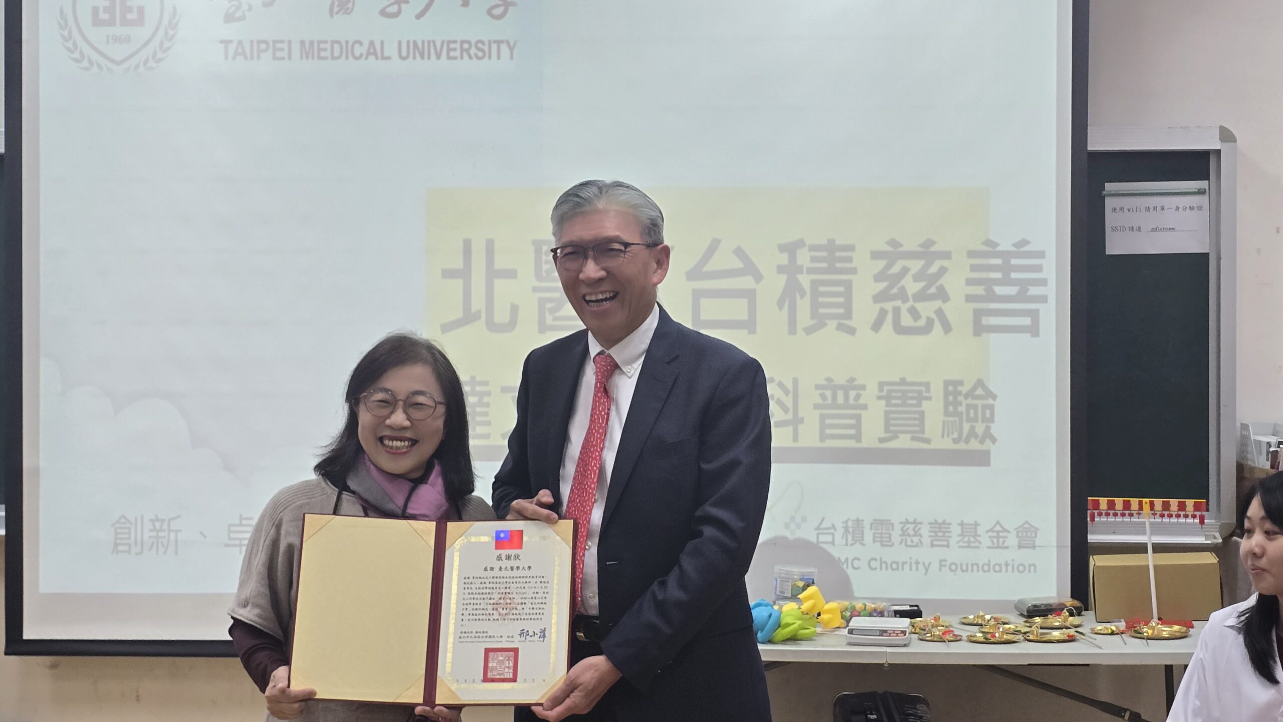 圖/古亭國小邢小萍校長(左)代表感謝台北醫學大學陳瑞杰董事長帶領師生將專業的醫學常識變成有趣的科學概念。(台積電慈善基金會 提供)