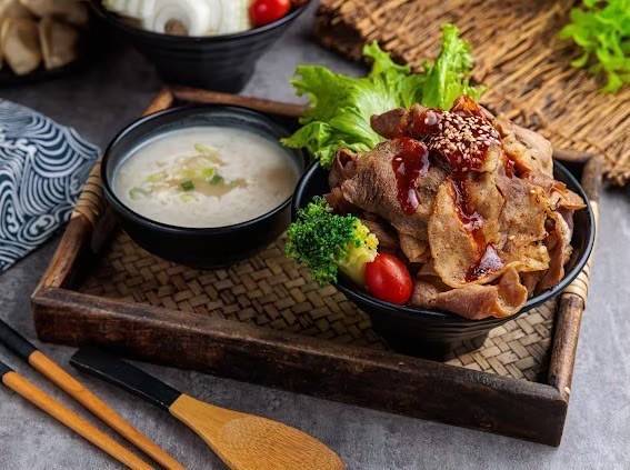 八町目燒肉丼飯的薄切燒肉搭配蔬食與湯品，飽足又均衡。(圖／食現餐飲集團)