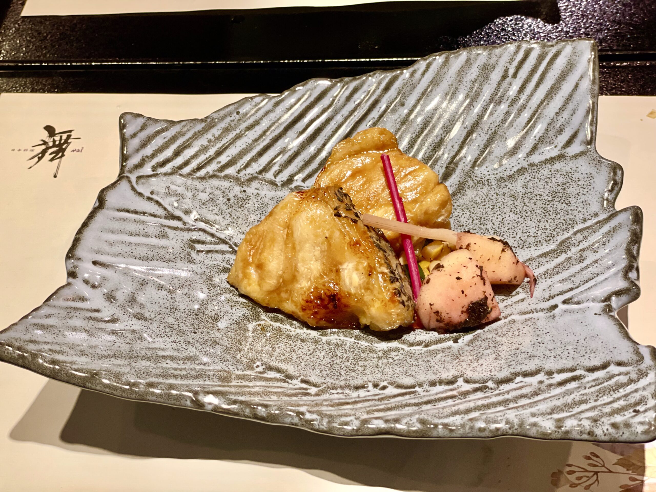 「節氣會席料理」的主餐「季節鮮魚味噌柚庵燒」，魚排烤至金黃，擺盤簡潔（圖／李昭弘）